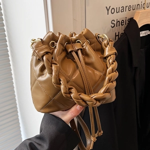 Chic caramel brown quilted bucket bag with woven handle and drawstring closure