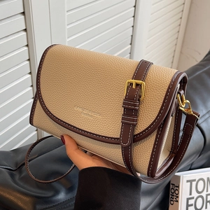 Sac bandoulière beige chic avec bordure marron et boucle dorée, porté main