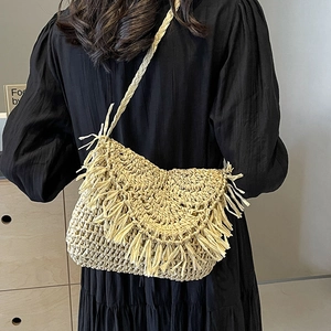 Bohemian beige straw crossbody bag with fringe tassel trim and a woven shoulder strap
