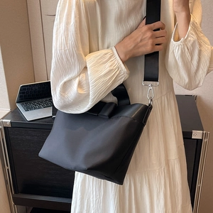 Black nylon bucket bag for women with a large bow detail and removable shoulder strap