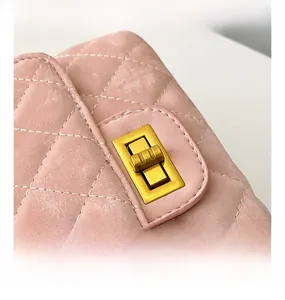 Gros plan du sac en cuir matelassé rose avec détail de fermoir rotatif en métal doré