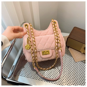 Détail du sac besace rose matelassé avec breloque rose dorée et chaîne en métal
