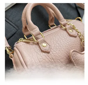 Nahaufnahme der rosa Handtasche mit Litschi-Lederstruktur und goldener Hardware