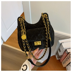 Détail du sac besace matelassé noir avec chaîne dorée et breloque fleur de camélia