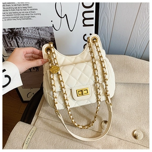 Détail du sac selle en cuir matelassé blanc avec breloque rose dorée et chaîne