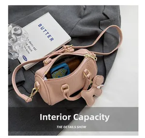 Innenkapazität der rosa Zylindertasche mit Geldbörse auf grauem Anzug und Buch