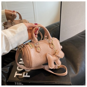 Nahaufnahme der rosa Zylinder-Handtasche aus Leder mit niedlichem Hunde-Anhänger