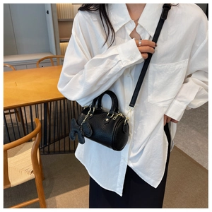 Schwarze Zylindertasche mit Litschi-Struktur, Metallkette und Hasenohr-Anhänger