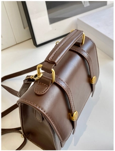 Detail of dark brown vintage leather backpack with golden buckle and sturdy handle