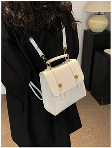 Rear view of a model wearing the white vintage leather backpack with gold buckle detail
