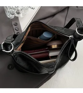 Top view of open black PU shoulder bag showing striped lining and spacious inner capacity