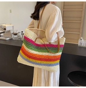 Close-up of rainbow striped woven tote bag with brown leather straps on a model