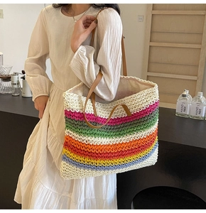 Detailed view of the large striped woven tote bag with brown faux leather shoulder straps