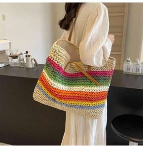 Detail of colorful woven tote bag with rainbow stripes and brown leather handles