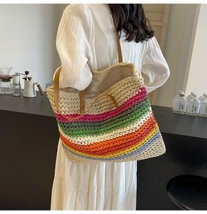Detail of a colorful rainbow striped woven tote bag with brown leather shoulder straps
