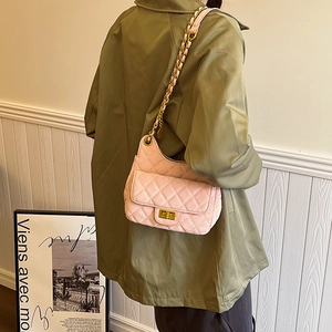 Sac à bandoulière rose matelassé avec chaîne dorée porté par un mannequin de dos
