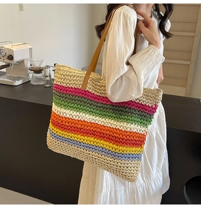 Detail of multi-colored striped woven tote bag with brown leather shoulder straps