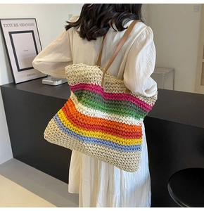 Close-up of colorful striped woven tote bag with premium brown leather straps and knit texture