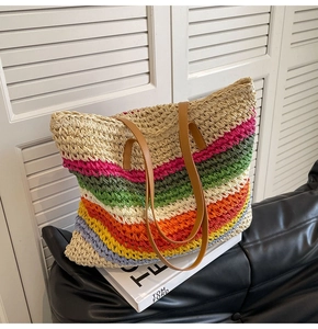Close-up of woven rainbow stripe tote bag with brown faux leather shoulder straps