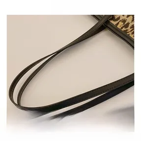 Detail shot of leopard print tote bag with black leather handle and precise stitching