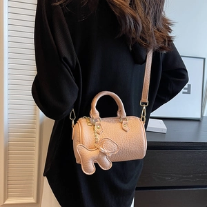 Schicke rosa Zylindertasche mit Kieselmaserung und süßem Welpenanhänger-Detail
