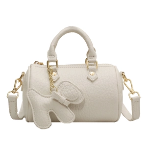 Schicke beige Zylindertasche aus Leder mit Hundeanhaenger und goldenen Beschlaegen