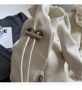 Détail du cabas en cuir blanc cassé avec fermoir en métal argenté et texture plissée