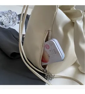 Détail de la poche latérale zippée sur un sac cabas en similicuir beige minimaliste