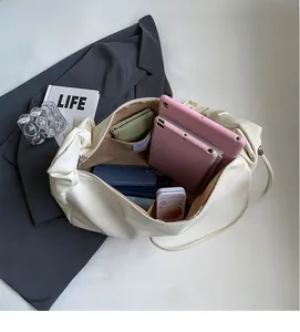 Vue intérieure du sac plissé blanc montrant une grande capacité pour tablettes et portefeuille