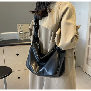 Détail de la bandoulière froncée sur un grand sac cabas noir pour femme élégant