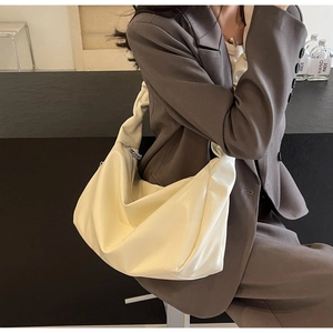 Détail du sac fourre-tout crème plissé montrant la texture en cuir PU souple et le zip argenté