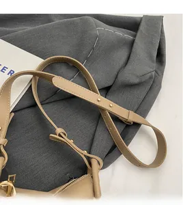 Detail of adjustable khaki leather strap with gold buckles and smooth zipper closure