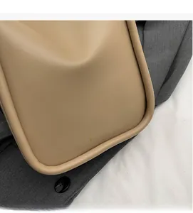Close-up of light brown leather bucket bag featuring a gold Fashion logo and smooth texture