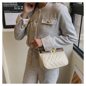 Close-up of beige quilted crossbody bag with brown leather flap and golden chain