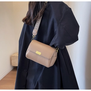 Detail of khaki leather crossbody bag with wide geometric strap and gold buckle