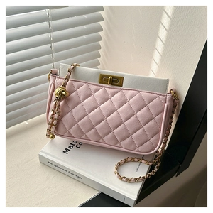 Detailed view of pink quilted leather bag with vintage gold metal lock and chain strap