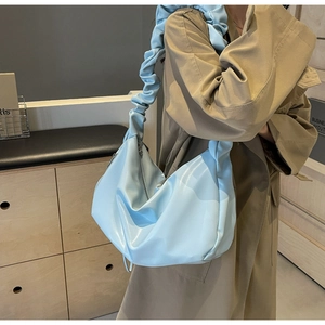 Détail du cabas bleu clair montrant la texture du cuir PU souple et la bandoulière plissée