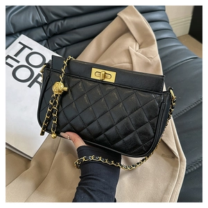 Close-up of black quilted shoulder bag featuring gold clasp and chain strap detail