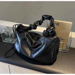Vue détaillée de la texture du cuir PU plissé noir et de la fermeture éclair argentée
