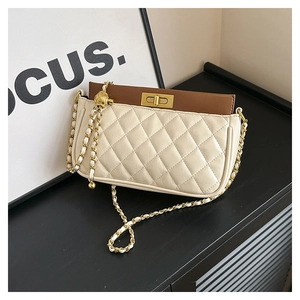 Detail of beige quilted leather shoulder bag with brown flap and gold ball chain strap