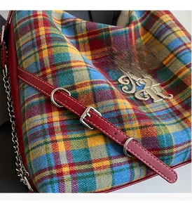 Detailed close-up of vibrant tartan fabric and premium silver metal hardware on a tote bag