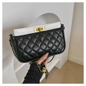 Detail of rhombic quilted bag featuring a golden ball chain and vintage turn-lock closure