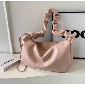 Détail de la poignée plissée rose d'un sac cabas en cuir souple avec fermeture éclair