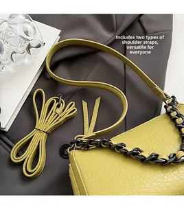 Detail of yellow lychee leather bag featuring chunky resin chain and thin shoulder strap