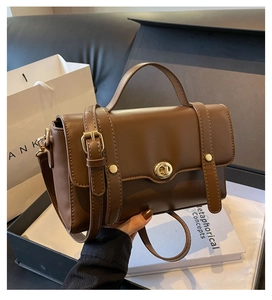 Gros plan détaillé d'un sac à main en cuir marron avec fermoir doré et bandoulière