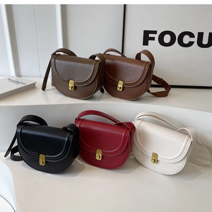 Detailed display of semi-circle saddle bags in various colors with golden metal twist locks