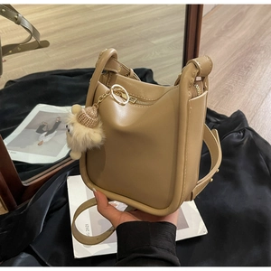 Detail of khaki bucket bag with U-shaped bottom and cute plush pendant decoration