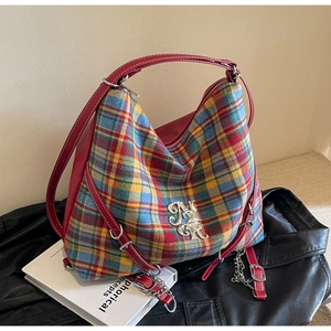 Close-up of British plaid canvas hobo bag with red leather trim and silver metal logo