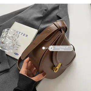 Detail view showing the side structure and wide base of the brown leather saddle bag