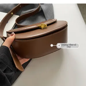 Close-up of the bottom stitching and structured base of a vintage brown saddle bag
